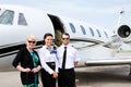 Pilot and stewardess with passenger by plane