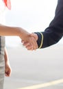 Pilot and stewardess shaking hands.