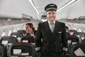 Pilot and stewardesses in passenger cabin of plane Royalty Free Stock Photo