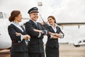 Pilot and stewardesses on runway near airplane jet Royalty Free Stock Photo