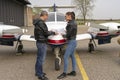 Pilot and Student Discussing Flight Route Over an Aviation Chart Royalty Free Stock Photo