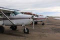 Light planes sitting on the wet packed sand bar