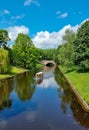 A yellow tourist boat sails through the waters of the canal