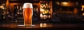 Pilsner glass of light beer on bar table in a dark pub with copy space. Generative AI Royalty Free Stock Photo