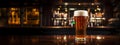 Pilsner glass of light beer on bar table in a dark pub with copy space. Generative AI Royalty Free Stock Photo