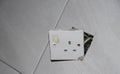 3-pin plug socket adapter hanging out from the wall Royalty Free Stock Photo