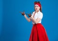 Pin-up female portrait. Beautiful retro woman in retro style with red lips and old- fashioned hairstyle, both hands pointing to th Royalty Free Stock Photo