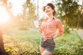 Pin up girl holds cardboard cup with a straw Royalty Free Stock Photo