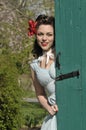 Pin up girl peeking behind a green barn door Royalty Free Stock Photo