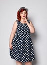 Pin up redhead woman . Beautiful retro female in polka dot dress with red lips and manicure nails and old fashion hairstyle