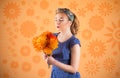 Pin-up woman portrait with bright colors and beautiful make-up in front of an orange background holding a bouqet in her hands Royalty Free Stock Photo