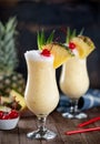 Pina colada cocktail with cherry, pineapple and leaves