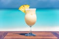 Pina colada coktail on wooden table at the beach