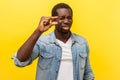 Pinching hand gesture. Portrait of positive man showing a little bit sign with fingers. indoor studio shot isolated on yellow