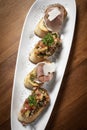 Pinchos tapas with jamon serrano and bruschetta on wood background