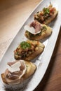 Pinchos tapas with jamon serrano and bruschetta on wood background