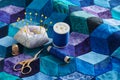 Pincushion, spools of thread, scissors and thimble on the tumbling blocks quilt background Royalty Free Stock Photo