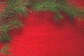 Pine branch on the red woolen background
