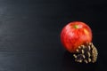 Pine cone, apple on black wooden background Royalty Free Stock Photo