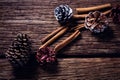 Pine cone and cinnamon sticks on wooden plank Royalty Free Stock Photo