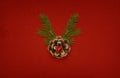 Pine Cone With Golden Glitter And Green Twigs Of Christmas Tree In A Shape Of Holiday Deer On Red Paper