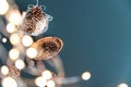 Pine cones and Christmas lights on a teal background