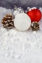 Pine Cones and Christmas Ornaments on a Snowy Background with Copy Space Royalty Free Stock Photo