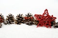 Pine cones with red star on snow in line on white Royalty Free Stock Photo