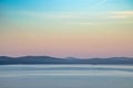 Pine forest overgrown with old mountains in the background and morning fog. Dawn over the Ural Lake Turgoyak Royalty Free Stock Photo