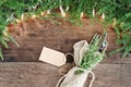 Pine Needles and Lights with Silverware and Card over Wooden Background