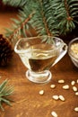 Pine nut oil and bowl of pine nuts on wooden background with cones, cedar brunches Royalty Free Stock Photo