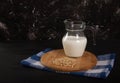 Pine nut vegetable milk in a glass jug stands on a wooden stand on a black background Royalty Free Stock Photo