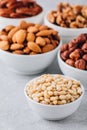Pine nuts, almonds, pecans, walnuts and hazelnuts in white bowls on grey background. Mixed nuts. Royalty Free Stock Photo