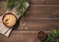Pine nuts in a bowl on a dark wooden background with branches of pine needles. The concept of a natural, organic and healthy Royalty Free Stock Photo