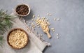 Pine nuts in a bowl and wooden scoop on a napkin on a blue texture background with branches of pine needles. The concept of a Royalty Free Stock Photo