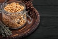 Pine nuts in a glass dish on a dark background with nuts scattered around Royalty Free Stock Photo