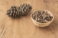 Pine nuts, kernels and cone on a wooden table