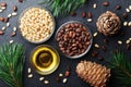 Pine nuts, oil and cedar cones on black table top view. Organic and healthy superfood.