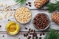 Pine nuts, oil and cedar cones on rustic wooden background top view. Organic and healthy superfood. Royalty Free Stock Photo