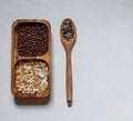 Pine nuts and pumpkin seeds in a wooden bowl and a large wooden spoon with sunflower seeds on a white background, on top Royalty Free Stock Photo