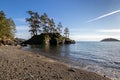 View of rocky island and trees from beach Royalty Free Stock Photo