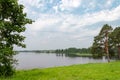 Pine trees on the lake bank opposite Ferapontovo monastery, Russia. Summer day, clouds in blue sky Royalty Free Stock Photo