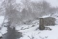 Pine trees and a refuge house covered in snow on a white winter landscape with a river crossing in Mondim de Basto, Portugal Royalty Free Stock Photo