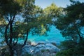 Pine trees on a rock over crystal clear turquoise water near Cape Amarandos at Skopelos island Royalty Free Stock Photo