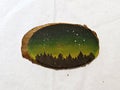 Pine trees under stars - painted on a wood slice