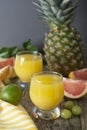 Pineapple cocktail or juice in glass jar bottle with straws and fruits on background - pineapple, oranges, grapefruit, lime and Royalty Free Stock Photo