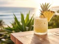 a pineapple cocktail on a table on a beach Royalty Free Stock Photo