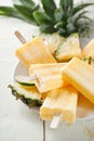 Pineapple coconut popsicles in a cluster on wooden white background Royalty Free Stock Photo