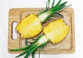 Pineapple cut halved, two halves. Lie on a wooden board, on a white background.