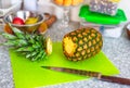 Pineapple with cutting top and knife on cutting board in domestic kitchen Royalty Free Stock Photo